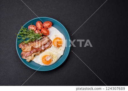 A hearty breakfast with fried eggs, bacon, tomatoes, microgreens A hearty breakfast with fried eggs, bacon, tomatoes, microgreens 124307689