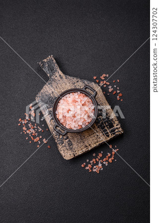 Pink himalayan salt in a black bowl on a dark concrete background Pink himalayan salt in a black bowl on a dark concrete background 124307702