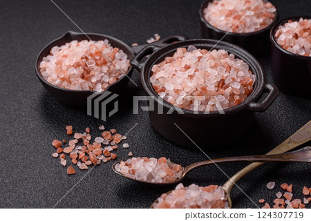 Pink himalayan salt in a black bowl on a dark concrete background 124307719