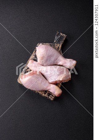 Raw chicken legs with salt, spices and herbs 124307911