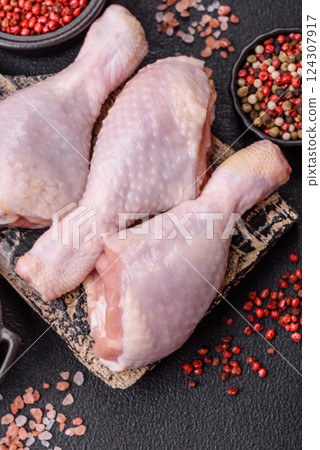 Raw chicken legs with salt, spices and herbs 124307917