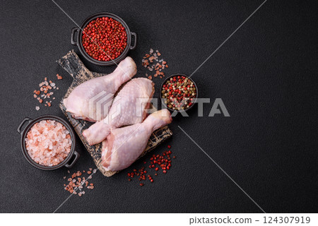 Raw chicken legs with salt, spices and herbs 124307919