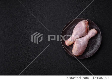 Raw chicken legs with salt, spices and herbs 124307922