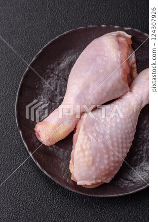 Raw chicken legs with salt, spices and herbs 124307926