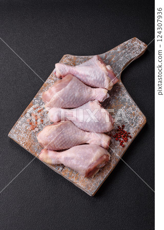 Raw chicken legs with salt, spices and herbs 124307936