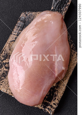 Fresh chicken fillet on a dark concrete table with spices and herbs Fresh chicken fillet on a dark concrete table with spices and herbs 124307990