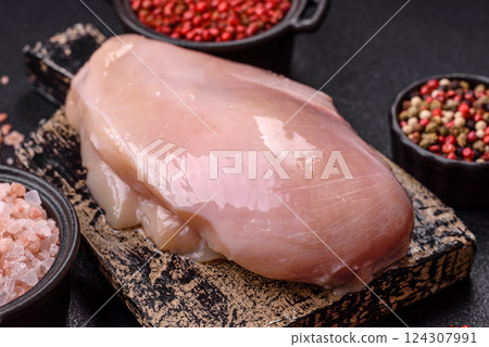 Fresh chicken fillet on a dark concrete table with spices and herbs Fresh chicken fillet on a dark concrete table with spices and herbs 124307991