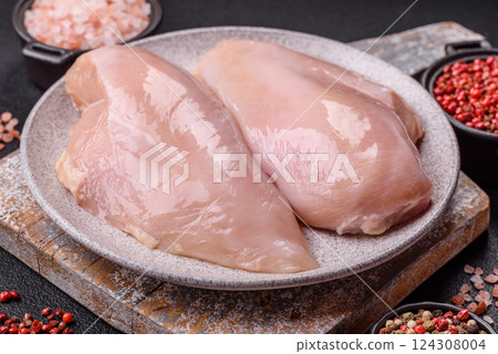 Fresh chicken fillet on a dark concrete table with spices and herbs Fresh chicken fillet on a dark concrete table with spices and herbs 124308004