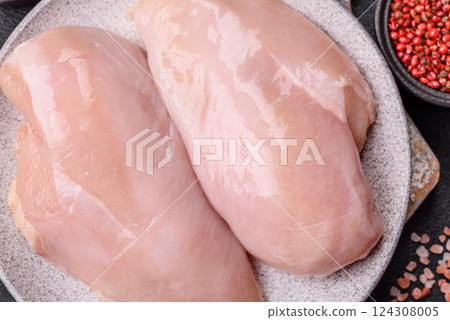 Fresh chicken fillet on a dark concrete table with spices and herbs Fresh chicken fillet on a dark concrete table with spices and herbs 124308005