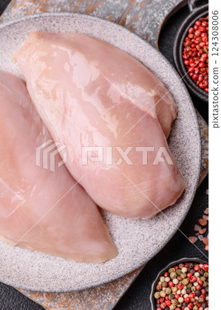 Fresh chicken fillet on a dark concrete table with spices and herbs Fresh chicken fillet on a dark concrete table with spices and herbs 124308006