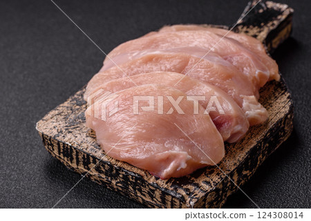 Fresh chicken fillet on a dark concrete table with spices and herbs Fresh chicken fillet on a dark concrete table with spices and herbs 124308014