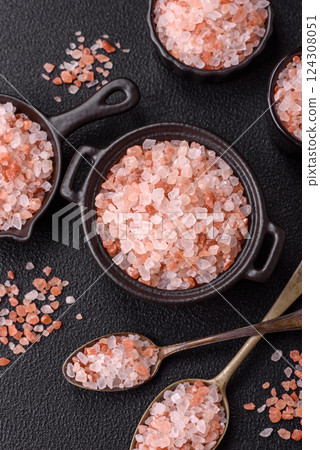 Pink himalayan salt in a black bowl on a dark concrete background Pink himalayan salt in a black bowl on a dark concrete background 124308051