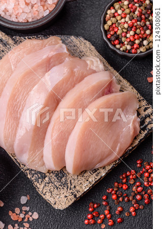Fresh chicken fillet on a dark concrete table with spices and herbs Fresh chicken fillet on a dark concrete table with spices and herbs 124308061