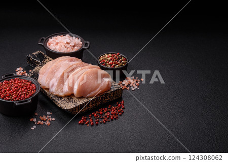 Fresh chicken fillet on a dark concrete table with spices and herbs Fresh chicken fillet on a dark concrete table with spices and herbs 124308062