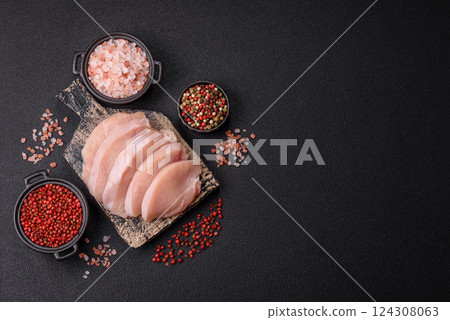 Fresh chicken fillet on a dark concrete table with spices and herbs Fresh chicken fillet on a dark concrete table with spices and herbs 124308063