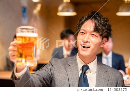 Male businessman toasting with beer at an izakaya 124308275