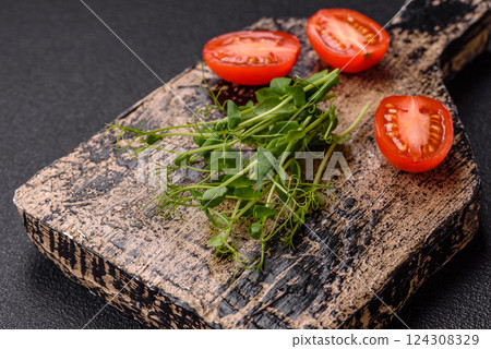 Sprigs of green fresh microgreen peas on wooden cutting board Sprigs of green fresh microgreen peas on wooden cutting board 124308329