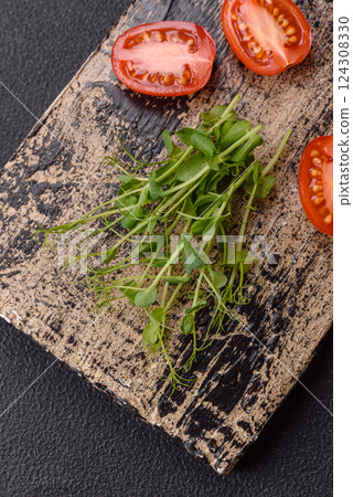 Sprigs of green fresh microgreen peas on wooden cutting board 124308330