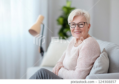 Smiling elderly woman in cozy living room enjoying peaceful afternoon at home 124308857
