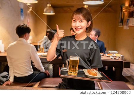 A young woman working in the hall of a pub 124308903