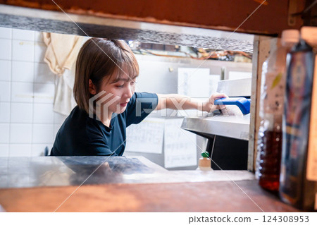 Restaurant staff washing dishes in a commercial dishwasher Restaurant staff washing dishes in a commercial dishwasher 124308953