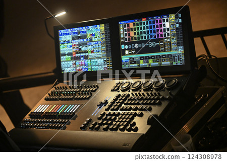 Lighting technician controls stage setup during evening concert in a vibrant venue with dynamic 124308978