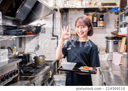 一名年輕女員工在餐廳廚房工作 一名年輕女員工在餐廳廚房工作 124309118