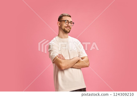 Smiling confident man crossing arms and looking aside in white shirt against pink background. Smiling confident man crossing arms and looking aside in white shirt against pink background. 124309210