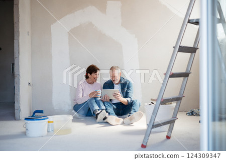 Senior couple renovating their home, browsing for inspirations on tablet. 124309347