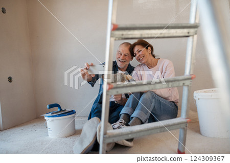 Senior couple taking break during their home renovation, taking a selfie. Senior couple taking break during their home renovation, taking a selfie. 124309367