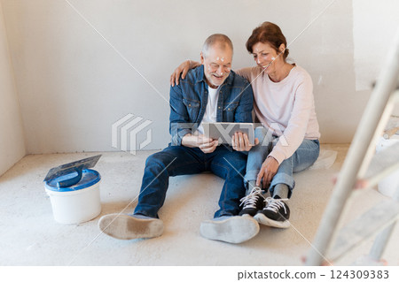 Senior couple renovating their home, browsing for inspirations on tablet. 124309383