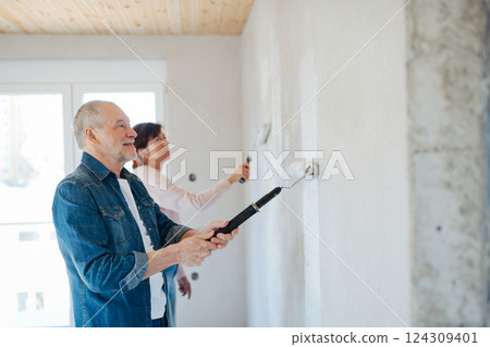 Senior husband and wife repainting the walls. Senior husband and wife repainting the walls. 124309401