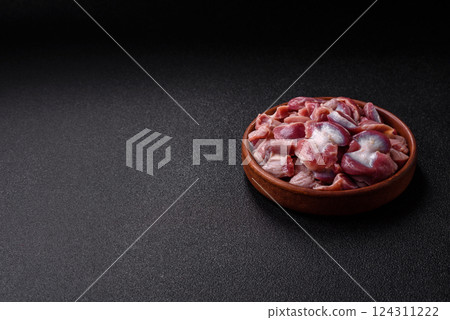 Raw chicken or turkey gizzards with salt, spices and herbs 124311222