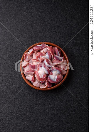 Raw chicken or turkey gizzards with salt, spices and herbs 124311224