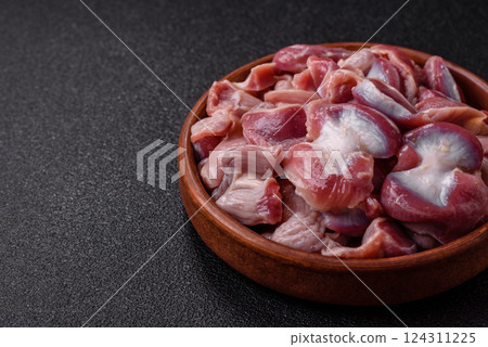 Raw chicken or turkey gizzards with salt, spices and herbs 124311225