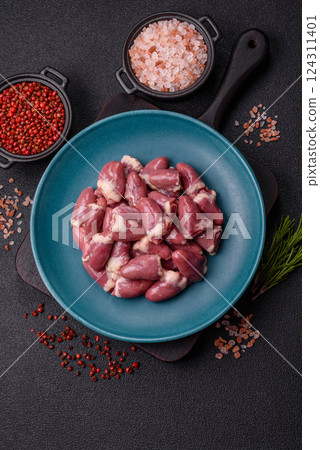 Raw chicken hearts with salt, spices and herbs Raw chicken hearts with salt, spices and herbs 124311401