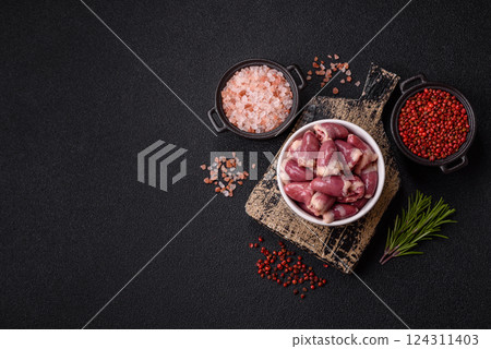 Raw chicken hearts with salt, spices and herbs 124311403