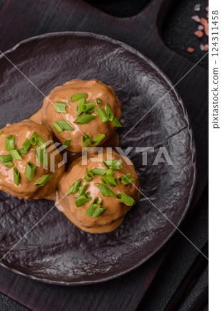 Meatballs with salt and spices in creamy caramel sauce 124311458