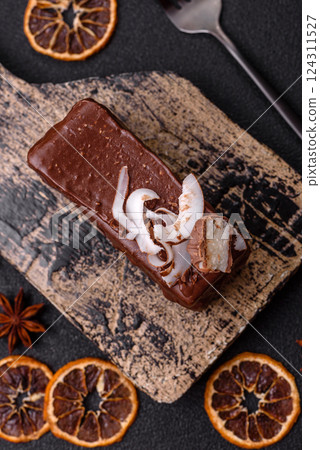 Piece of sweet chocolate bounty cake with coconut flakes and sponge 124311527