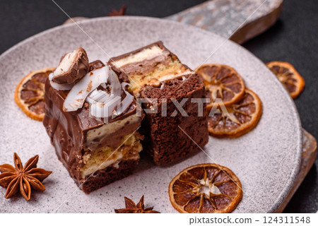 Piece of sweet chocolate bounty cake with coconut flakes and sponge Piece of sweet chocolate bounty cake with coconut flakes and sponge 124311548