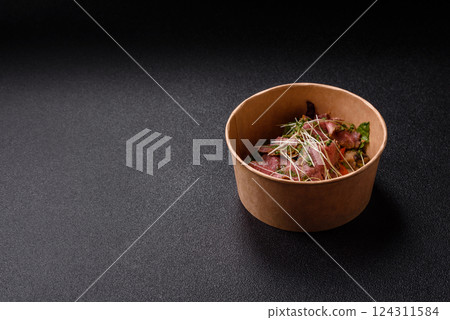 Warm salad consisting of slices of roast beef, greens, tomatoes, cucumbers, green beans 124311584