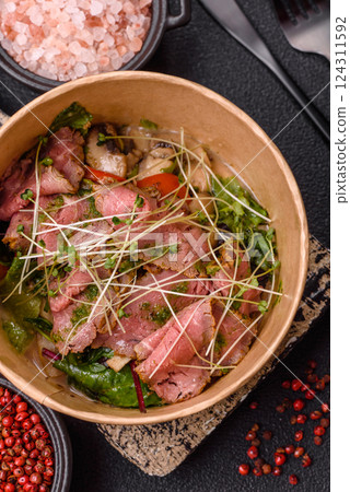 Warm salad consisting of slices of roast beef, greens, tomatoes, cucumbers, green beans 124311592