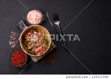 Warm salad consisting of slices of roast beef, greens, tomatoes, cucumbers, green beans 124311594