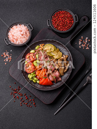 Warm salad consisting of slices of roast beef, greens, tomatoes, cucumbers, green beans 124311606