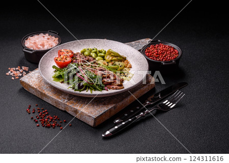 Warm salad consisting of slices of roast beef, greens, tomatoes, cucumbers, green beans 124311616