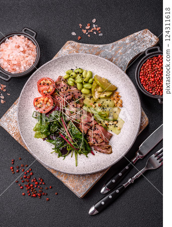 Warm salad consisting of slices of roast beef, greens, tomatoes, cucumbers, green beans 124311618