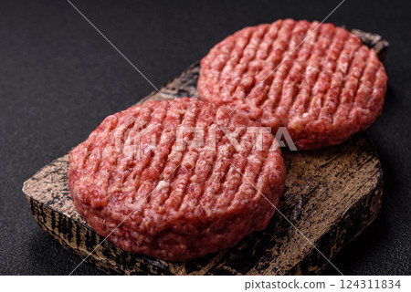 Fresh raw ground beef burger patty with salt and spices Fresh raw ground beef burger patty with salt and spices 124311834