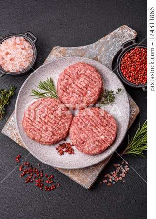 Fresh raw ground beef burger patty with salt and spices 124311866