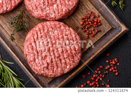 Fresh raw ground beef burger patty with salt and spices 124311874