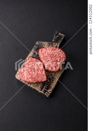 Raw beef or pork burger patty in the shape of a heart Raw beef or pork burger patty in the shape of a heart 124312002